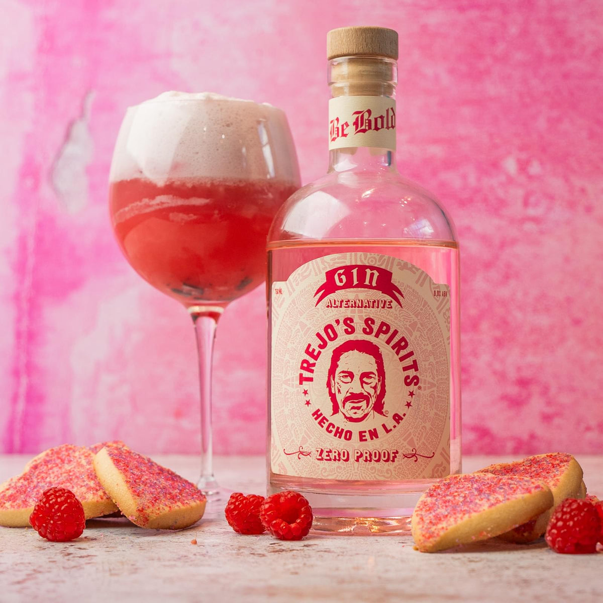 Gin Alternative bottle with a raspberry gin float and pink cookies