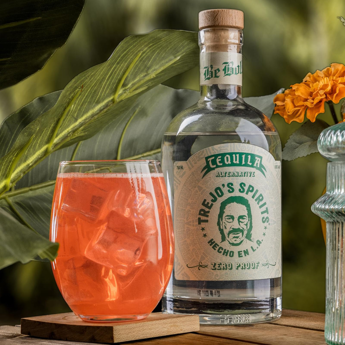 Tequila Alternative bottle beside a pink cocktail on ice